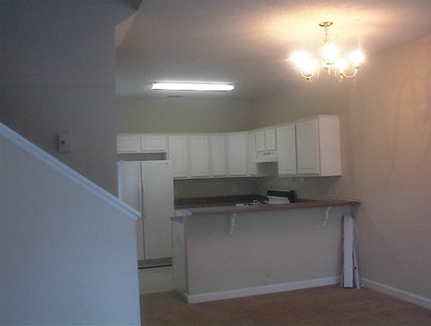 A kitchen with white cabinets and a counter.