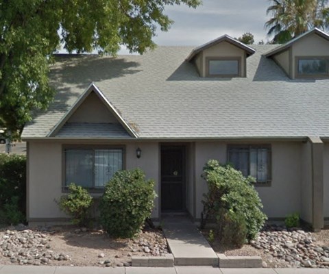 A house with a grey roof and a black door.