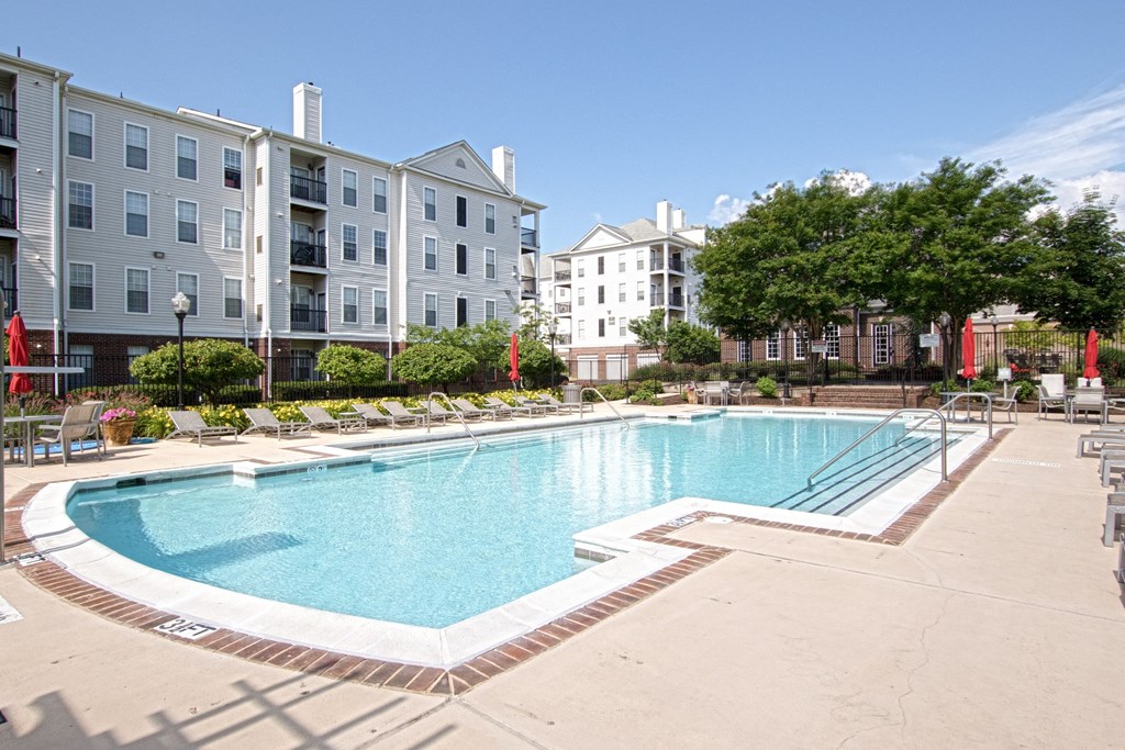 a swimming pool with an apartment building in the background