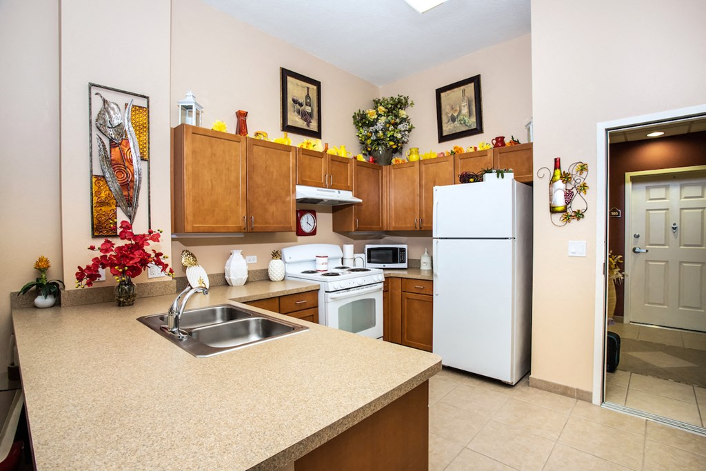 entrance way into kitchen with appliances, cabinetry, and tile flooring