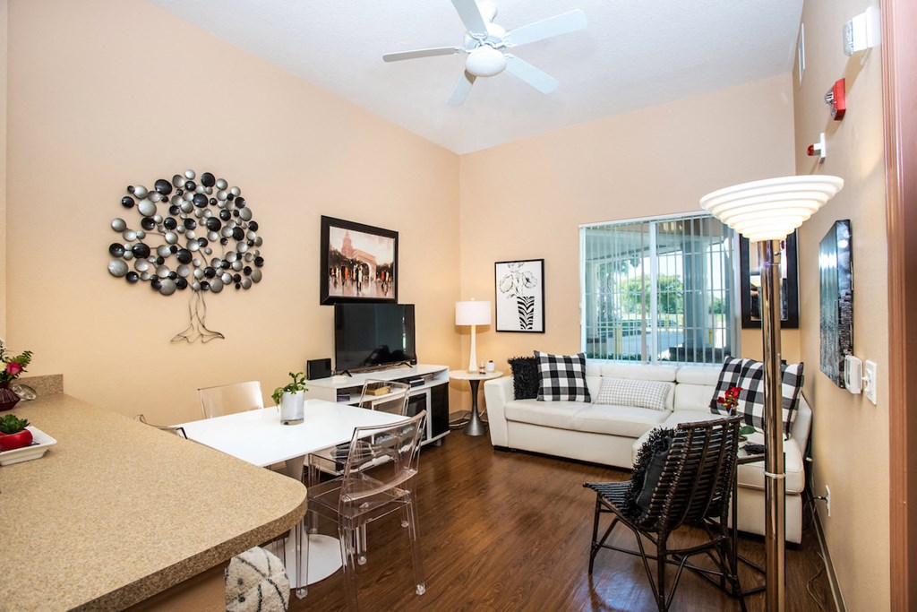 living room with high ceilings, fan, and large window