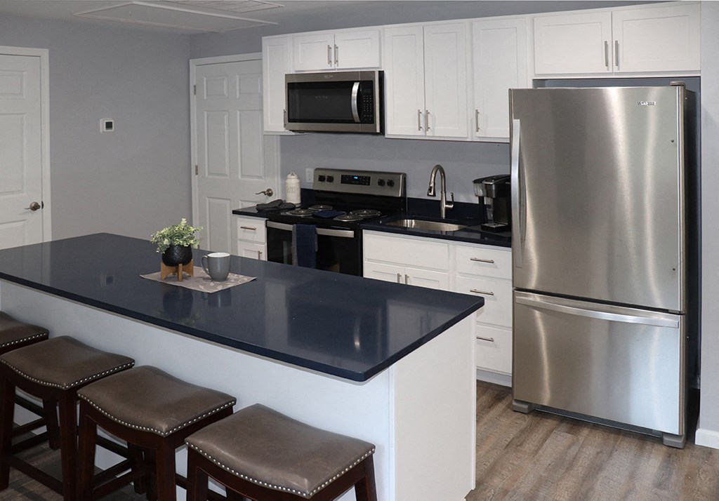 a kitchen with stainless steel appliances and a black counter top