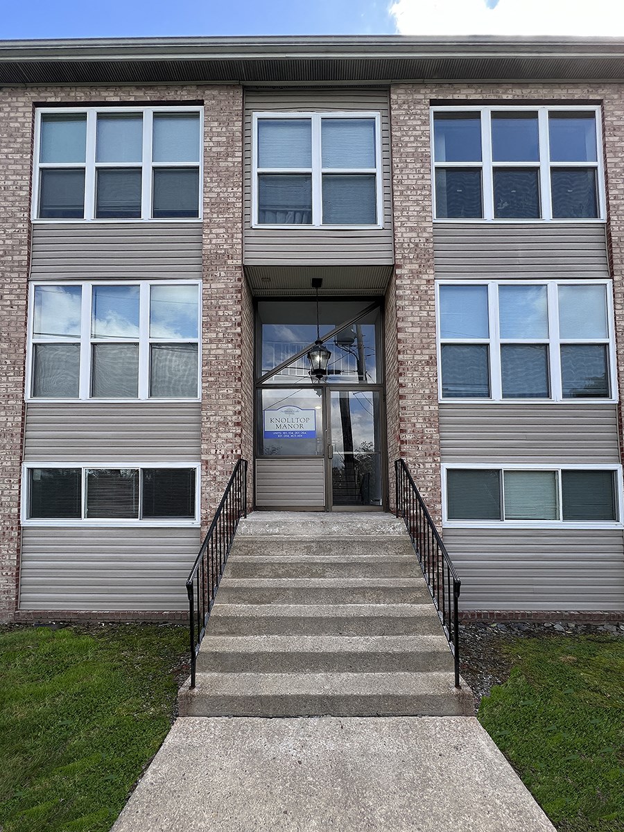 the front of a building with stairs in front of it