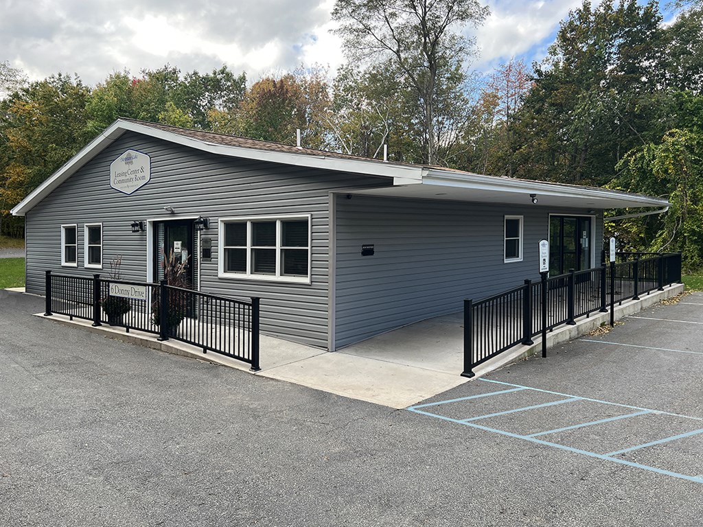 a gray building with a black fence and a parking lot