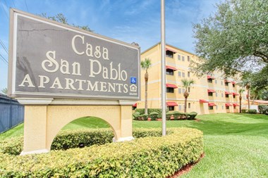 Monument sign with community name "Casa San Pablo Apartments" in front of building