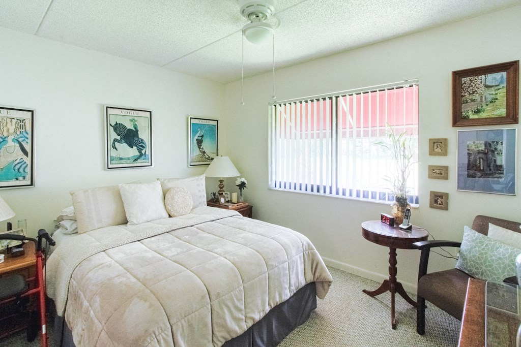 bedroom with ceiling fan, window, berber carpet, and model furnishings