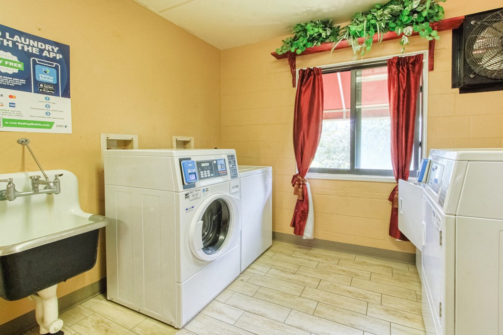 community laundry room with washers, dryers, and laundry sink