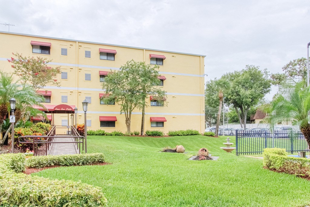 lush lawn at Casa San Pablo Senior Apartments with mature trees and decorative grasses