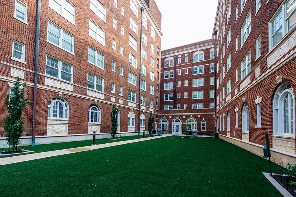 courtyard with artificial grass surrounded on three sides by red brick building at Residences at Forest Park, Saint Louis, Missouri