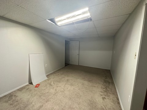 A room with a carpeted floor and a white door.