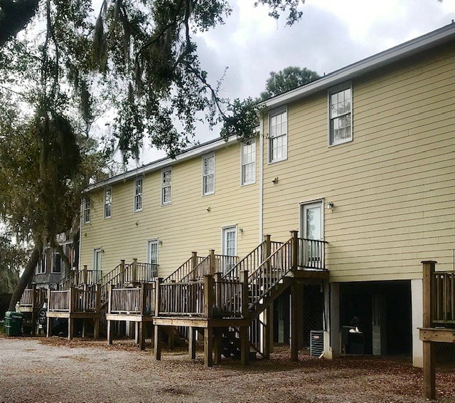 a yellow house with a wooden deck and a ramp