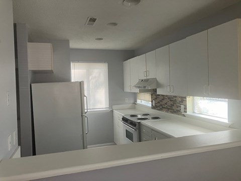 A kitchen with a white countertop and a refrigerator.