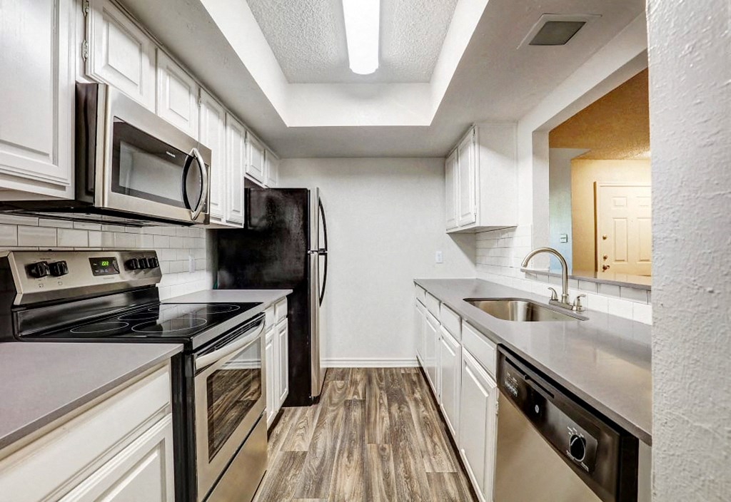 a kitchen with stainless steel appliances and white cabinets