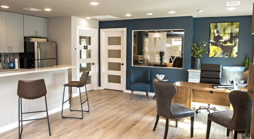 a living room with a table and chairs and a kitchen