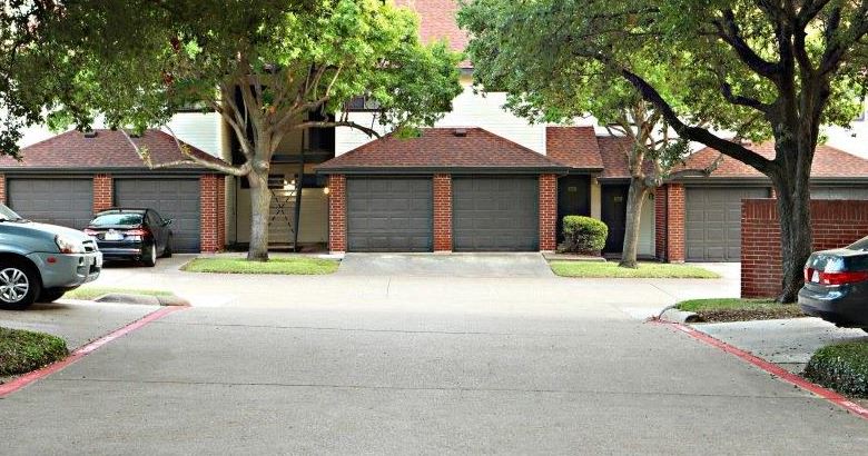 a street with cars parked in front of a house