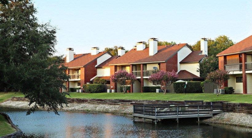 a row of houses next to a lake with a dock