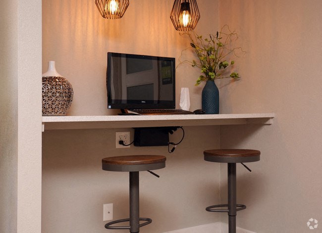 a desk with two stools and a computer on it
