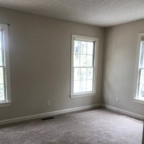 a large empty room with two windows in it