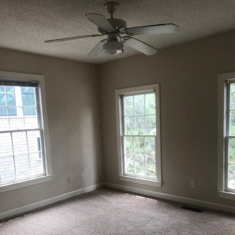 a living room with a ceiling fan and two windows