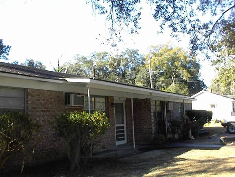 the front of a brick house with a car in the driveway