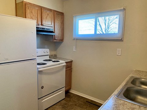 a kitchen with a stove refrigerator and a window