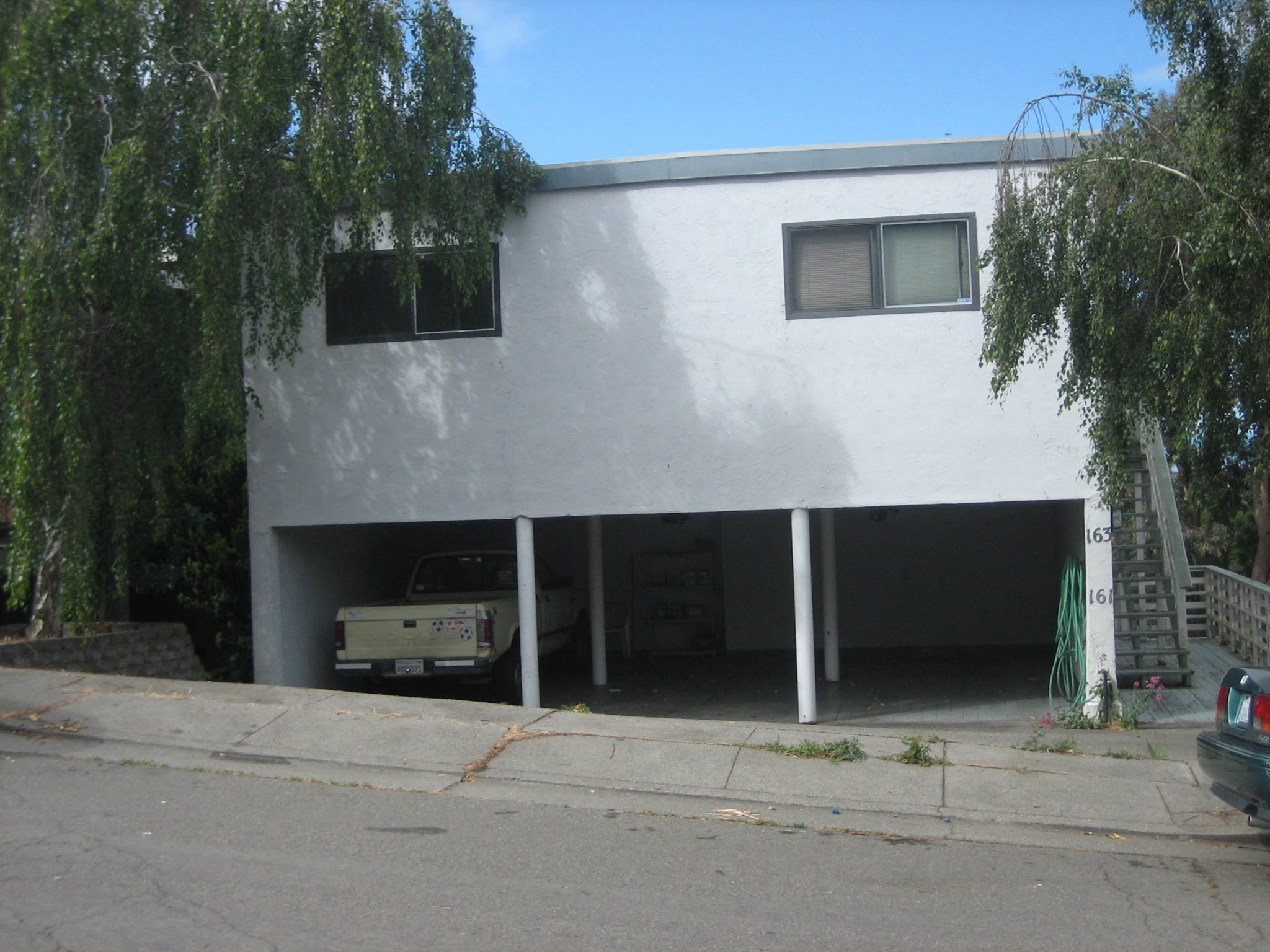 the front of a white house with a car garage