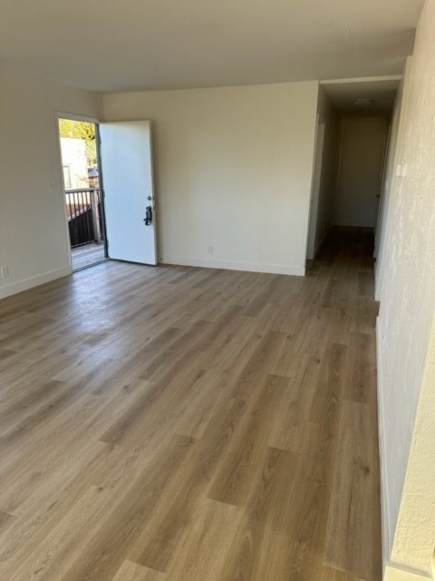 an empty living room with a wooden floor