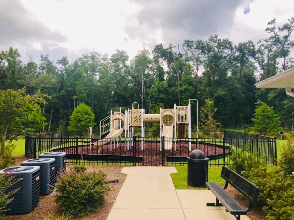 a playground in a park with benches and a swing set