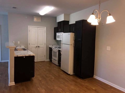 an empty kitchen with a refrigerator and a stove