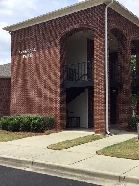 a brick building with a balcony and a sidewalk