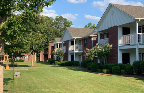 our apartments are located in the community with a green lawn and trees
