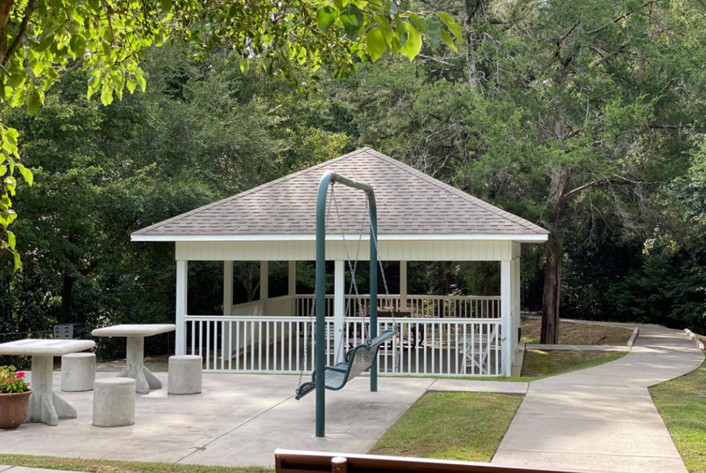 a gazebo with a swing set in a park