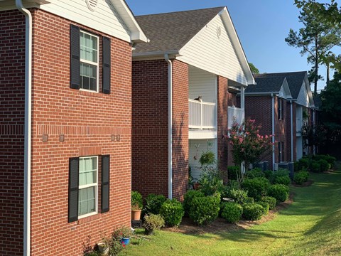 a brick house with a yard in front of it
