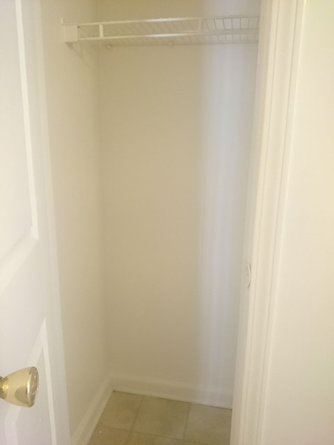 a small closet in a bathroom with a white door