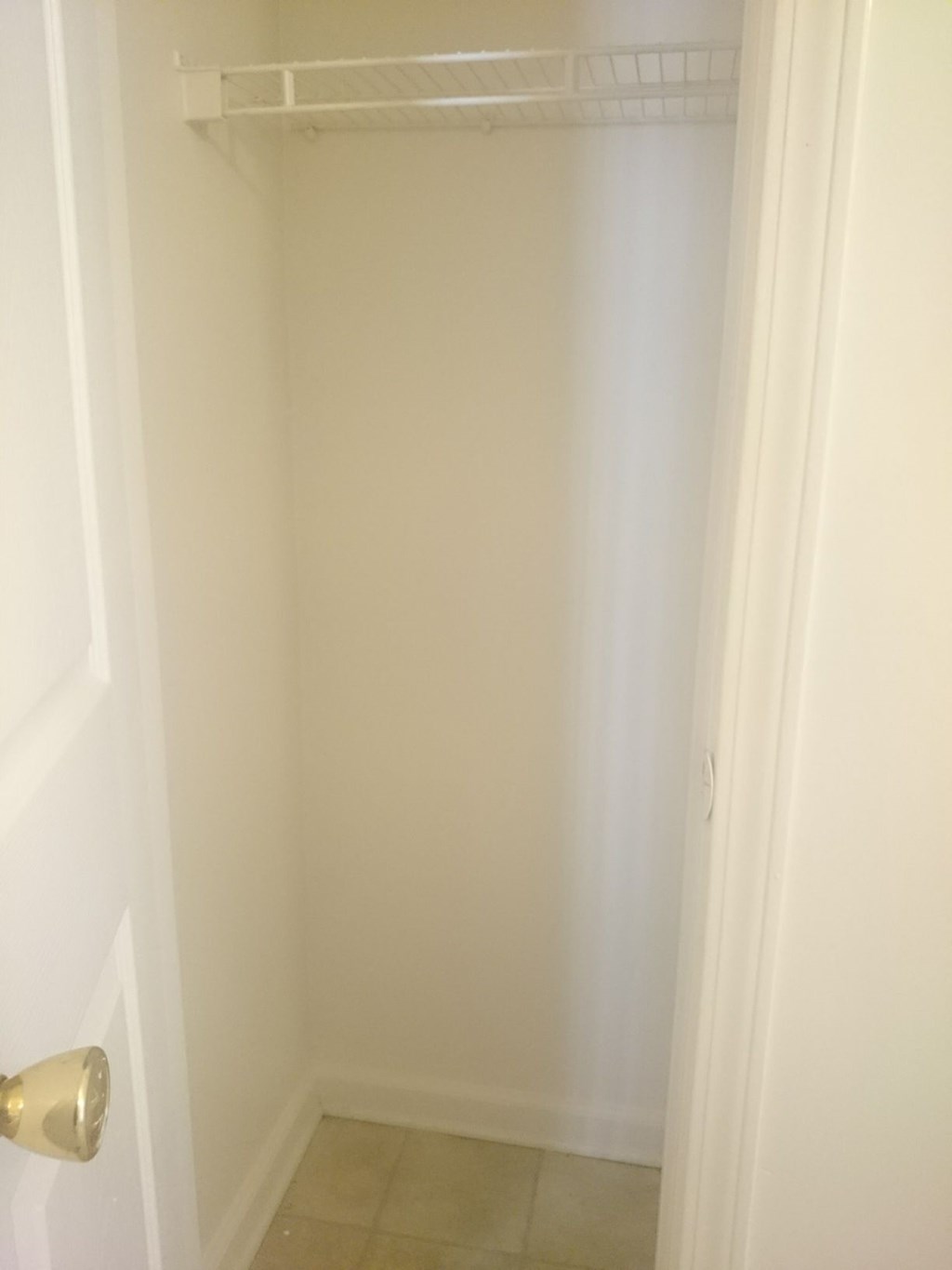 a small closet in a bathroom with a white door