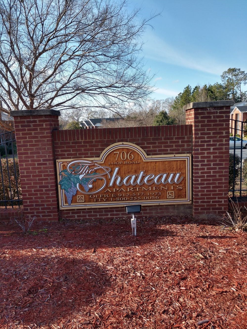 a sign for shakespeare park in front of a brick wall