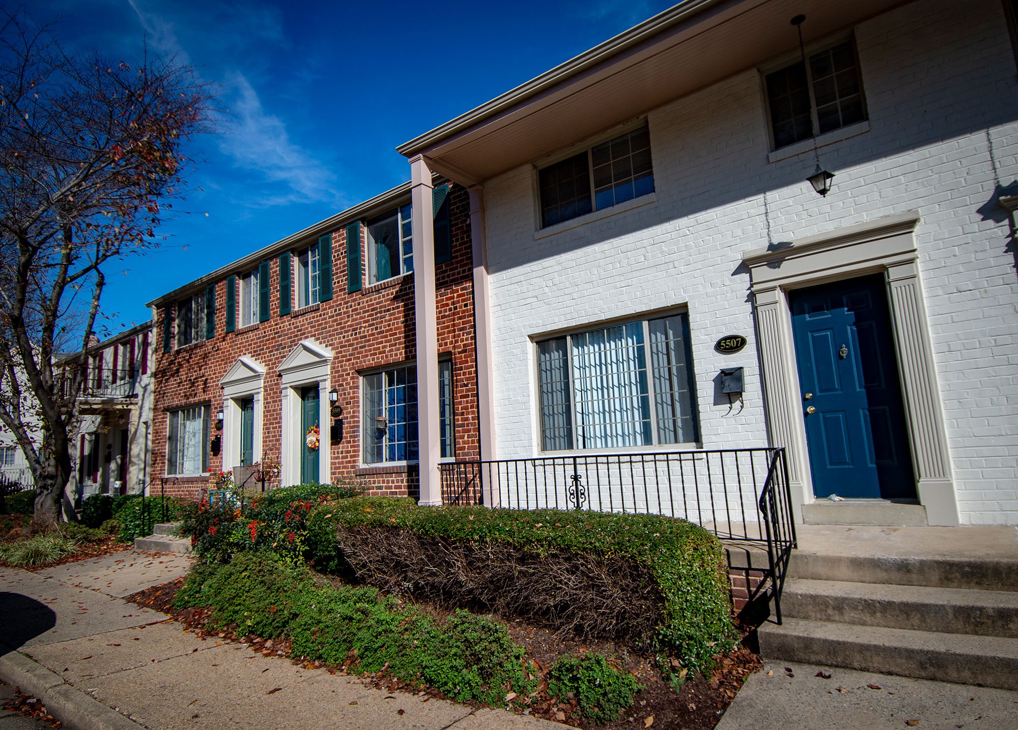 a building with a blue door and a sidewalk in front of it