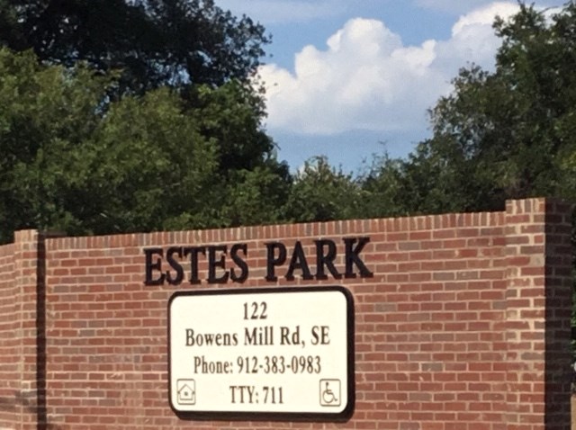 the sign for estates park on a brick wall