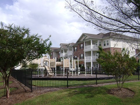 an apartment building with a fence in front of it