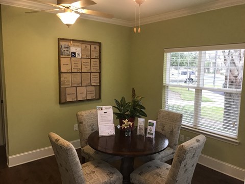a dining room with a table and chairs and a bulletin board on the wall