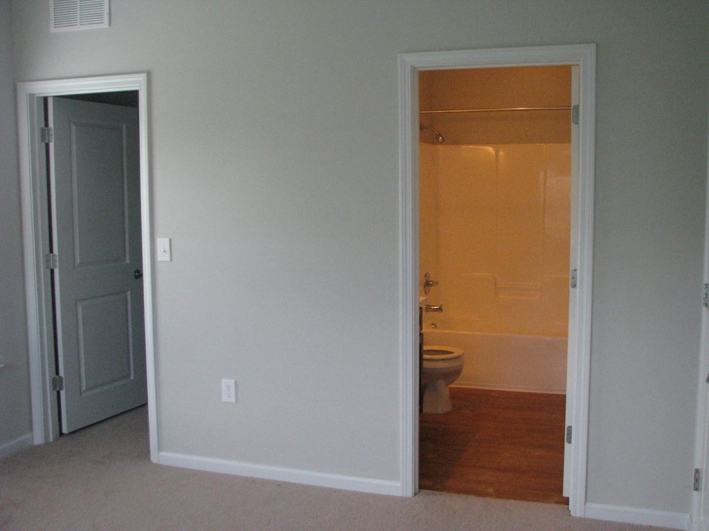 an open door leading to a bathroom with a toilet
