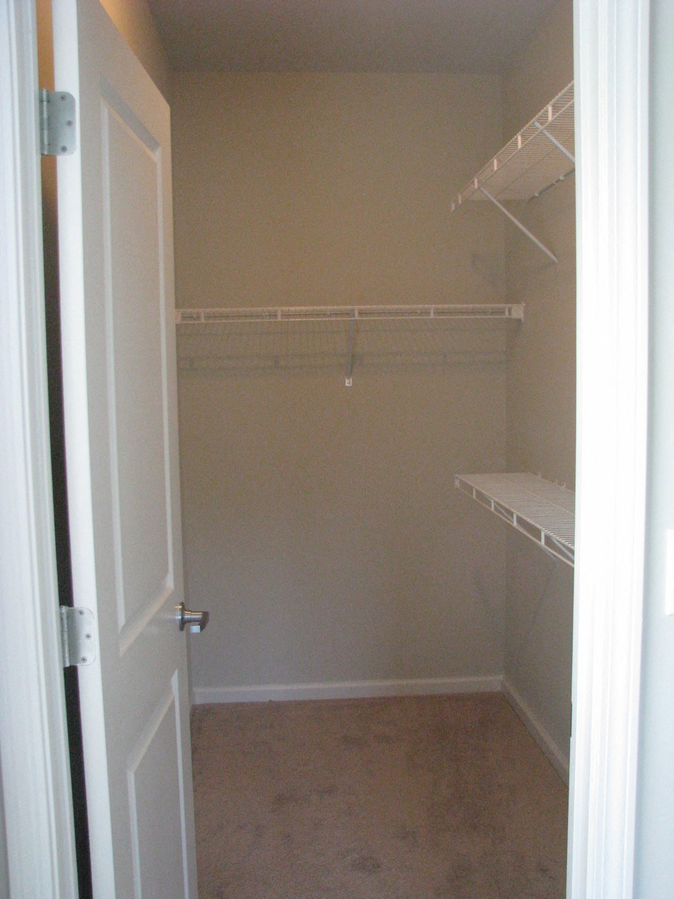 a walk in closet with shelves and a white door