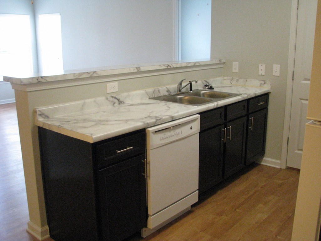 a kitchen with white marble counter tops and black cabinets