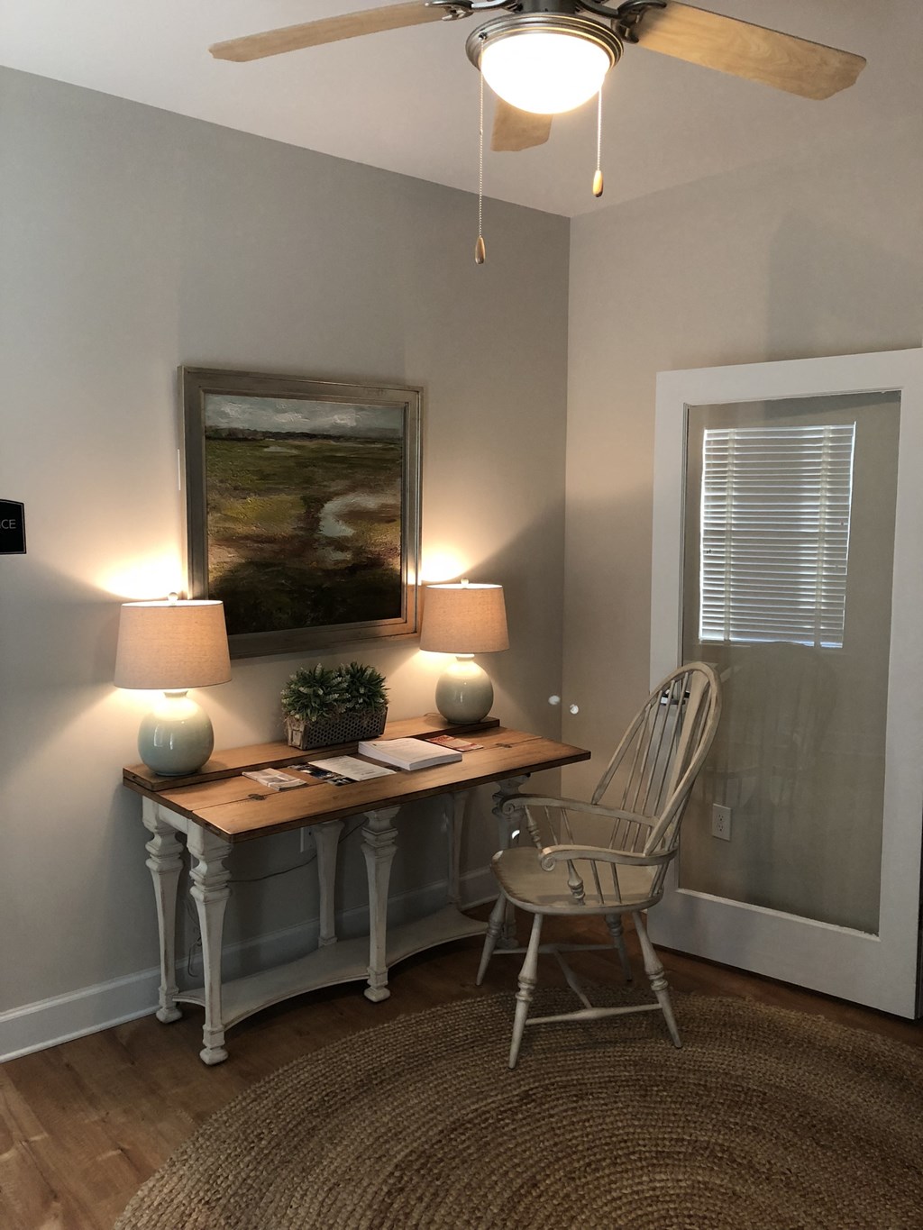 a home office with a desk and chair and a painting on the wall