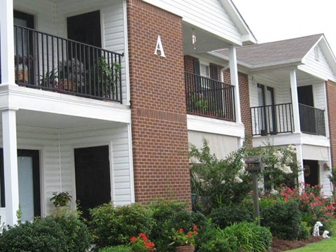 a brick house with a porch and a balcony