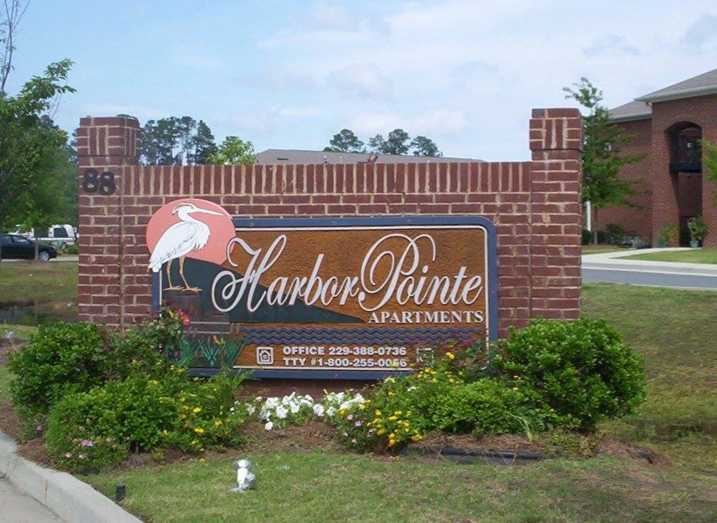 a sign is on the side of a brick wall