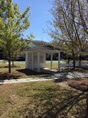 a gazebo in the middle of a park with trees
