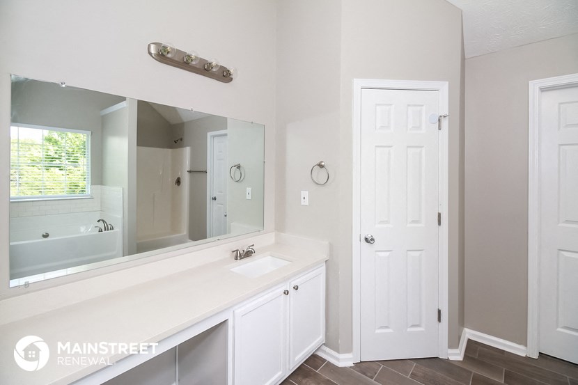 a bathroom with a large mirror and a sink and a tub