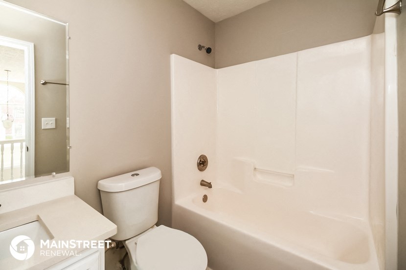 a bathroom with a tub and a toilet and a sink