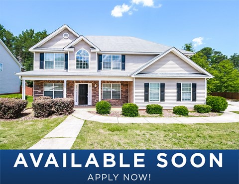 a white house with a lawn and a path in front of it